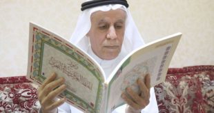 المؤلف ممسكاً بكتاب «رموز الخط العربي في البحرين»